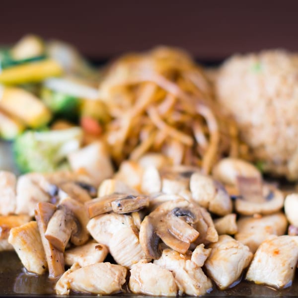 Hibachi Boy's chicken and mushrooms with fried rice, onions, and zucchini in the background.