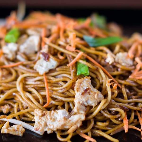 Close-up of Hibachi Boy's Japanese noodles with chicken, shredded carrots, and green onions.