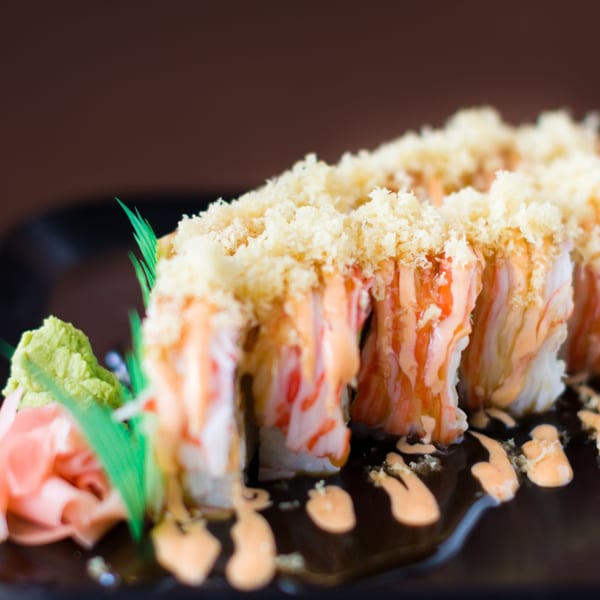 Hibachi Boy's sushi roll with crab, sauce, and tempura flakes, served with wasabi and ginger.